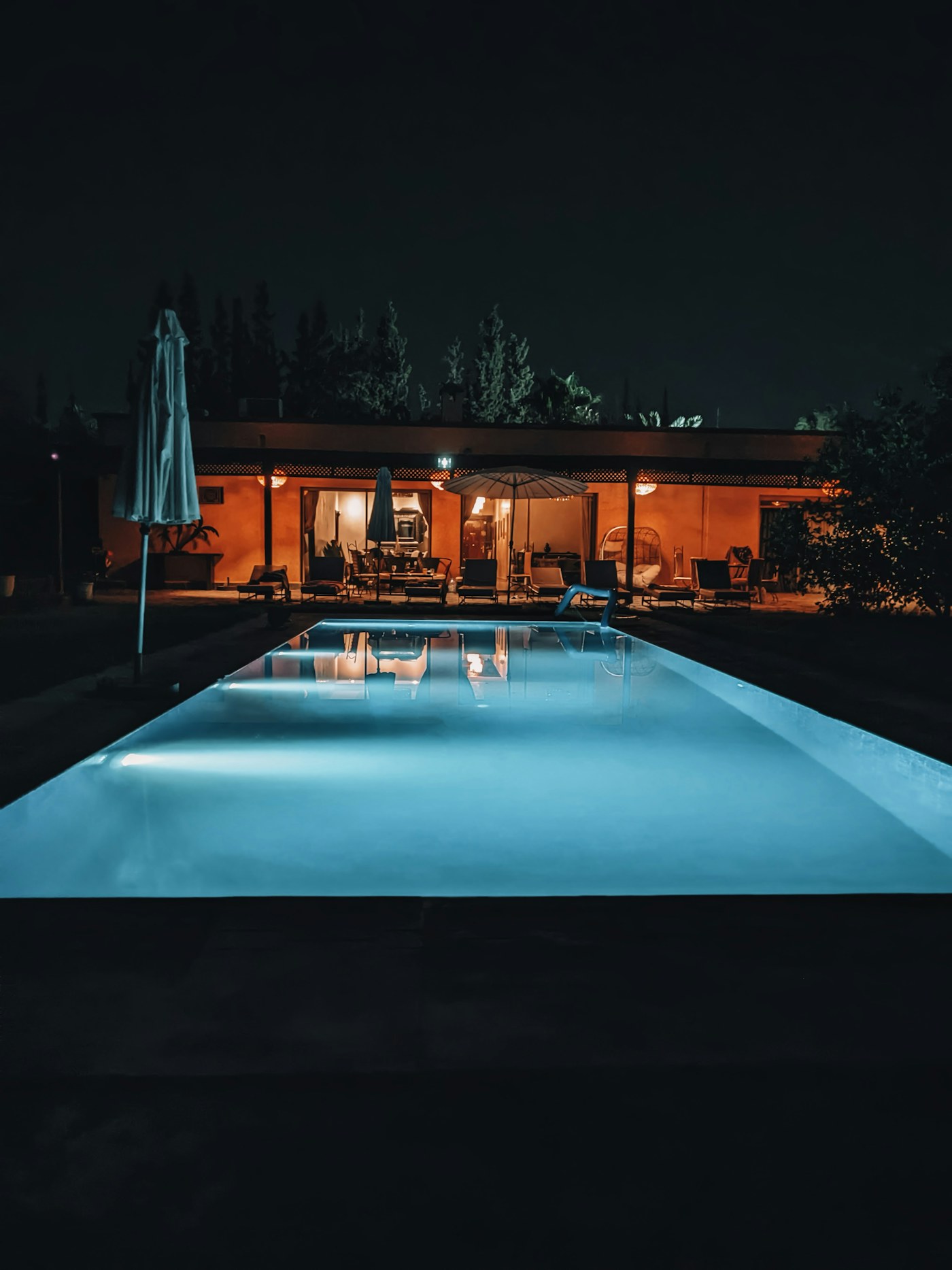 Piscine rectangulaire minimaliste éclairée la nuit