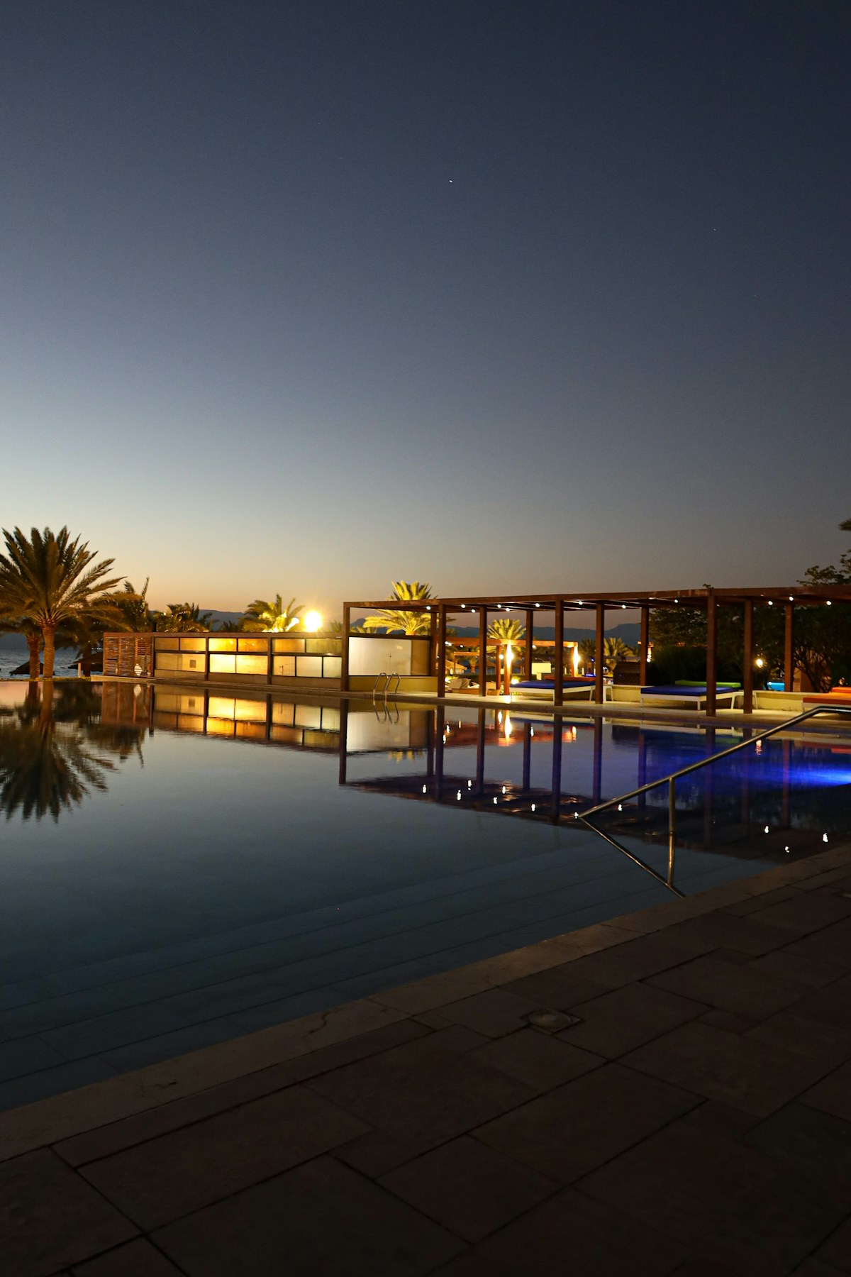 Piscine à débordement élégante au coucher du soleil